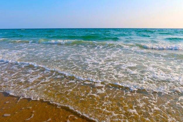 Foto playa con olas y fondo de agua de mar azul