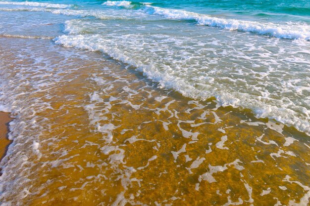 Foto playa con olas y fondo de agua de mar azul