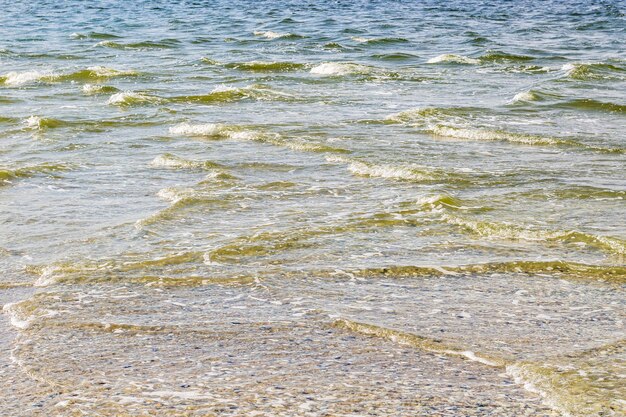 Playa a orillas del mar y pequeñas olas unas hacia otras