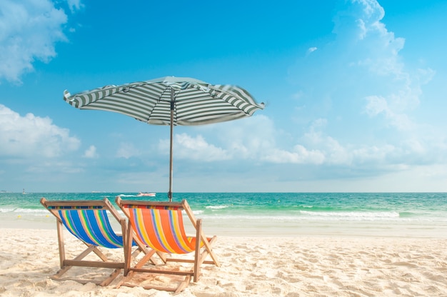 Playa paraguas y sillas para relajarse en la hermosa playa de arena blanca