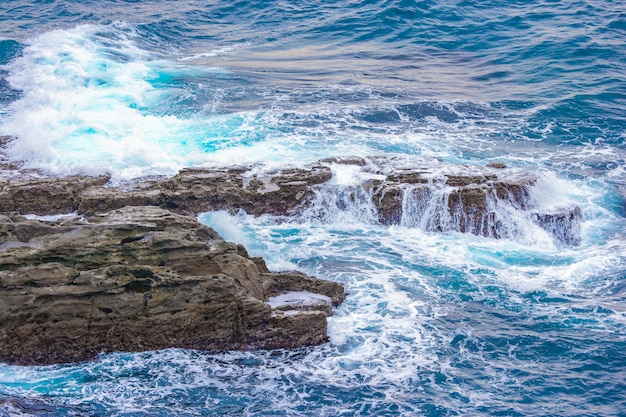 Playa de piedra del acantilado de SANDANBEKI con agitar el mar azul.