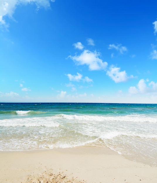 Playa Poetto bajo un cielo azul con nubes