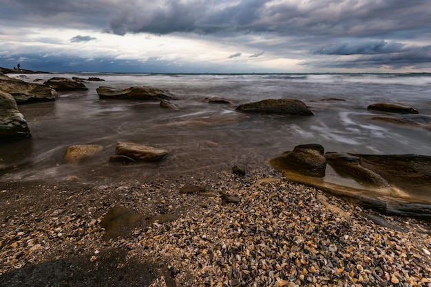 Una playa con rocas y el cielo de fondo