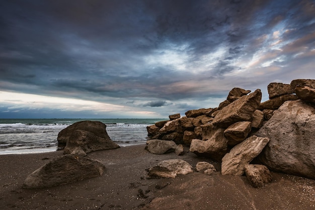 Una playa con rocas y un cielo nublado