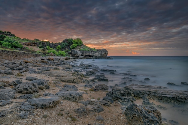 Una playa con rocas y un cielo nublado