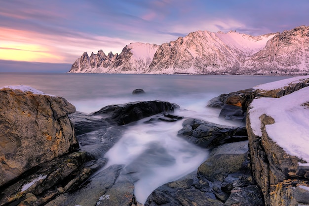 La playa rocosa y las piscinas al atardecer en Ersfjord. Isla Senja en la región de Troms en el norte de Noruega. Tiro de larga exposición