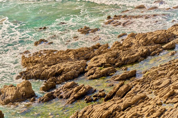 Foto playa rocosa con vista de día soleado en altura