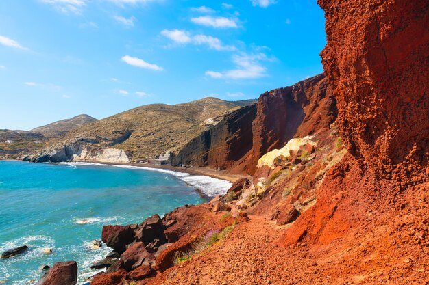 Foto playa roja en la isla de santorini grecia acantilados volcánicos rojos y el mar azul