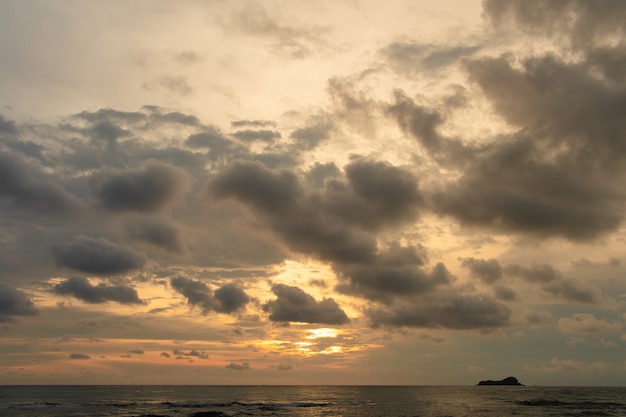Playa de la salida del sol de la mañana con el cielo nublado.