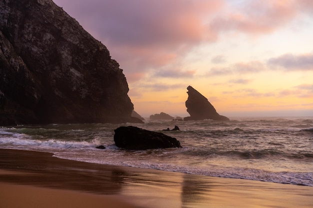 Playa salvaje del océano clima tormentoso Praia da Adraga playa de arena con un paisaje pintoresco de fondo Sintra Cascais Portugal