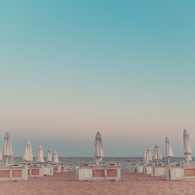 Playa con sombrillas y tumbonas cerradas por la tarde.