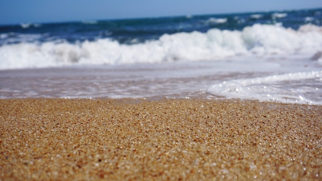 Foto playa tropical. fondo de la onda del océano. arena y mar azul. naturaleza del agua del océano, relax en la playa. vacaciones de verano en el mar