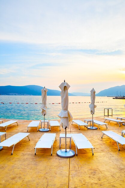 Playa con tumbonas y sombrillas al atardecer, Montenegro