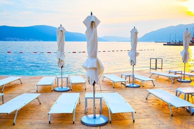 Playa con tumbonas y sombrillas al atardecer, Montenegro