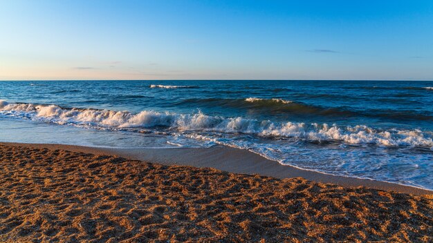 Playa vacía con arena amarilla y olas azules, cuarentena en el resort