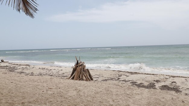 Playa vacia em un dia nublado con una fogata en la orilla toma amplia