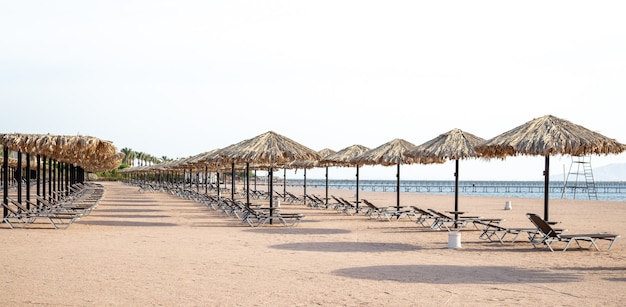 Playa vacía con tumbonas y sombrillas. Crisis turística durante la cuarentena.