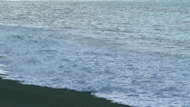 La playa de verano la naturaleza hermosa superficie del mar oscuro la orilla de la marea las grandes olas se estrellan en cámara lenta