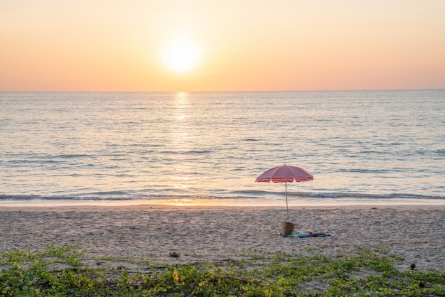 Playa de verano y sombrilla roja por concepto de vacaciones