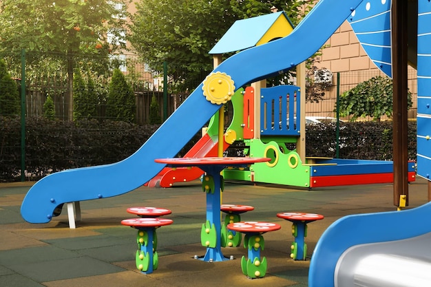 Playground ao ar livre para crianças com cadeiras de mesa coloridas engraçadas e escorregador