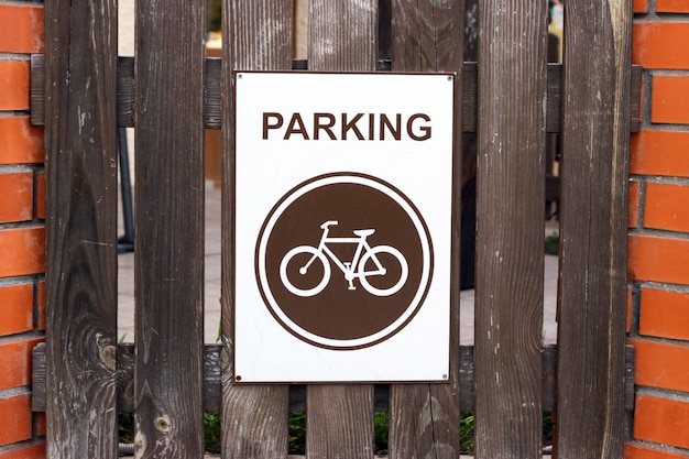 Una plaza de aparcamiento para bicicletas, un cartel en una valla de madera.