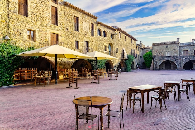 Plaza central del pueblo medieval de Monells con sus casas de piedra y arcos en los edificios Girona España