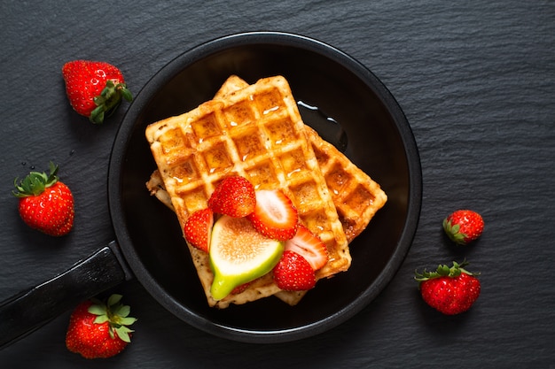 Plaza del concepto de comida Waffles y jarabe con fresa e higo con espacio de copia