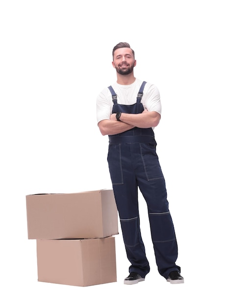 En pleno crecimiento, un hombre sonriente parado cerca de cajas de cartón.