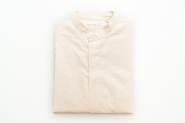 Pliegue de la camisa beige aislado en la superficie blanca