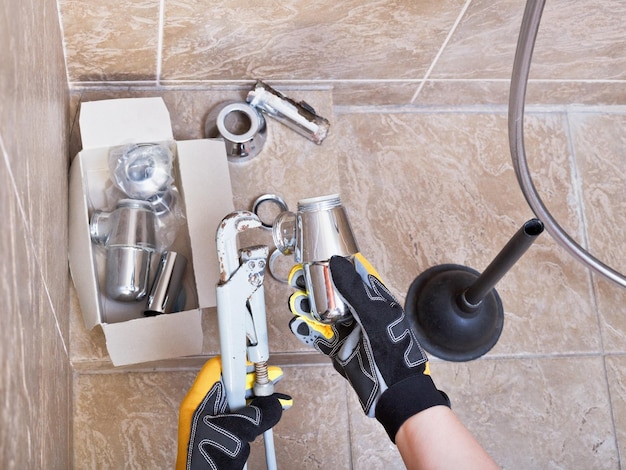 Plomero repara trampa de lavabo en el baño