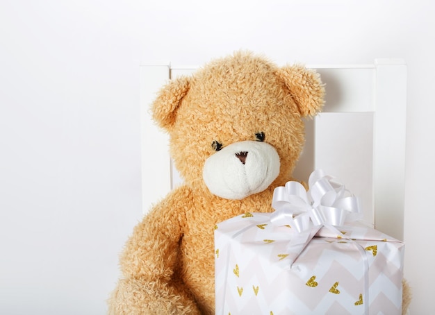 Plüschteddybär mit Geschenken auf grauem Hintergrund. Nahaufnahme