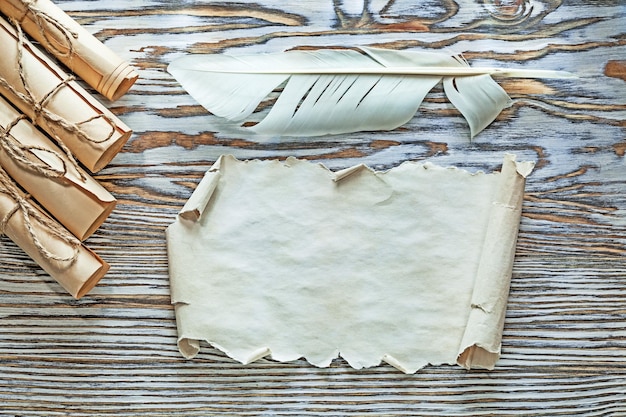 Pluma de pergaminho de rolos de papel com fio vintage na placa de madeira.