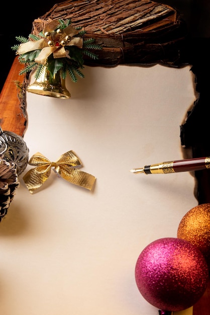 Pluma estilográfica una hermosa pluma estilográfica una hoja en blanco con bordes quemados y adornos navideños Enfoque selectivo