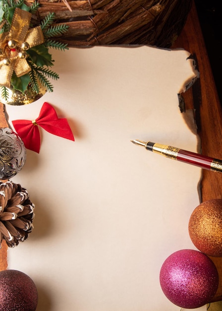 Pluma estilográfica una hermosa pluma estilográfica una hoja en blanco con bordes quemados y adornos navideños Enfoque selectivo