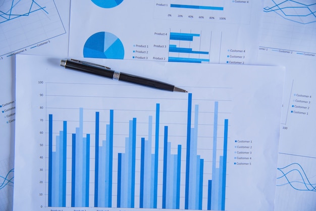 Pluma en gráfico de diagrama y gráficos informe empresarial con dinero, brújula, calculadora en el escritorio del asesor financiero. Concepto de Contabilidad y Planificación Financiera. vista superior.