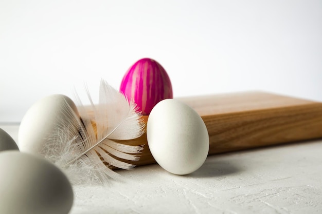 Pluma de huevo pintada sobre un fondo de tablero de madera El concepto mínimo Una tarjeta de Pascua