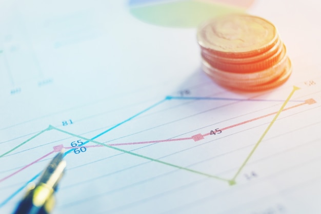 Pluma y moneda en el documento comercial. Tabla de informes