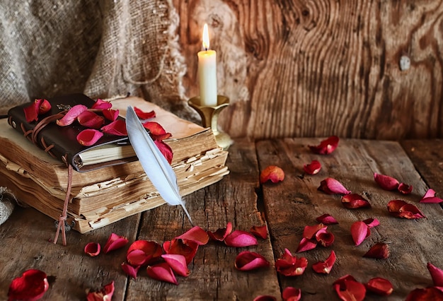 Pluma y novela de libro cerca de una vela.