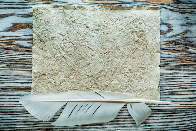 Pluma de papel vintage sobre tabla de madera