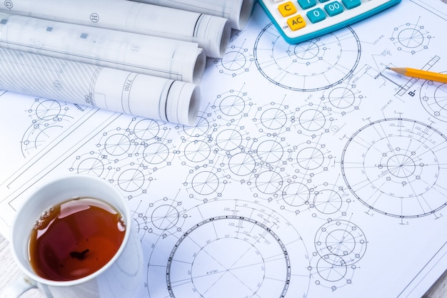 Pluma, té y calculadora en la mesa de papel con diagrama