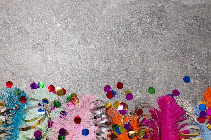 Plumas y confeti sobre fondo gris espacio para texto