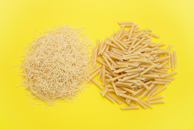 Plumas de pasta y filini sobre un fondo amarillo