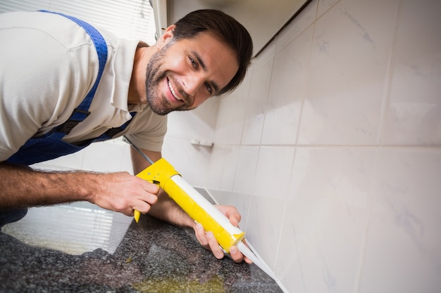 Plumber que coloca o enchimento dentro das telhas