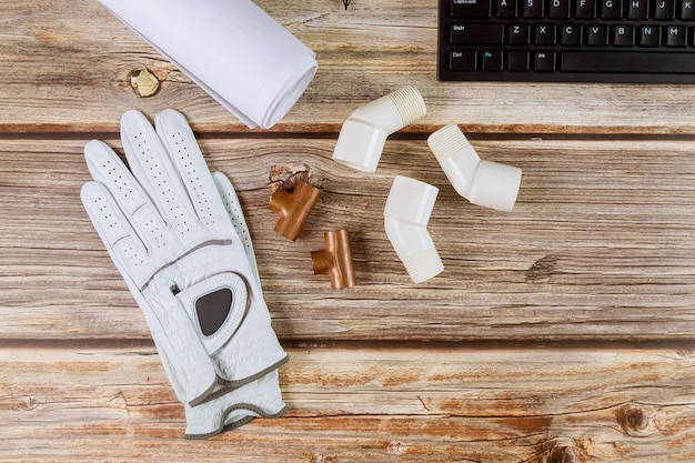 Plumbing construtor escritório tubos de cobre e projetos de construção luvas de proteção teclado de computador