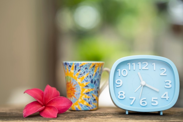 Plumeria despertador y taza de café concepto de pausa para el almuerzo