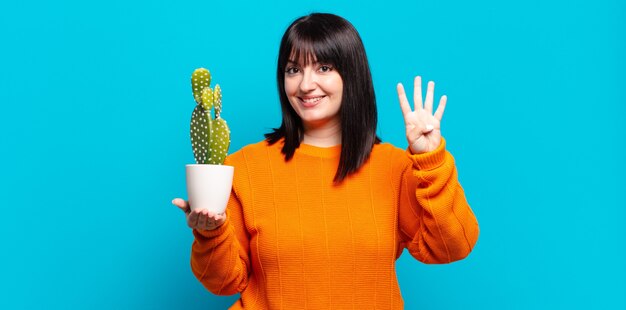 Plus Größe hübsche Frau lächelnd und freundlich aussehend, zeigt Nummer vier oder vierten mit der Hand nach vorne, Countdown