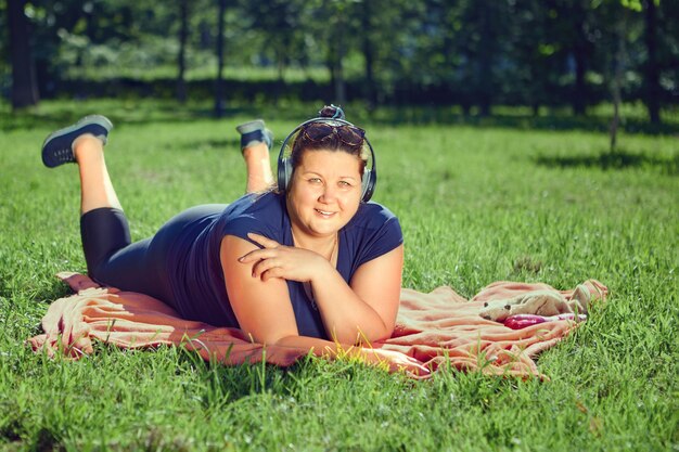 Plus Size Body positive Frau liegt auf dem Bauch in der Mitte von l