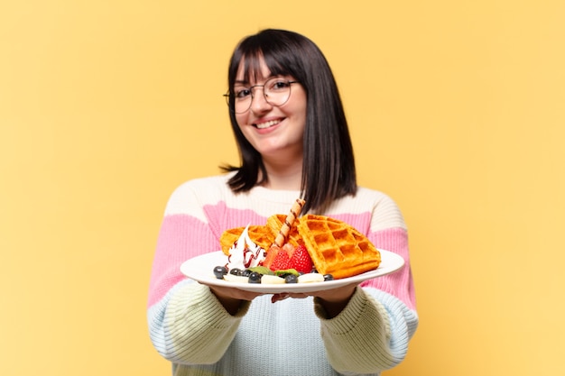 Plus Size hübsche Frau, die Waffeln isst