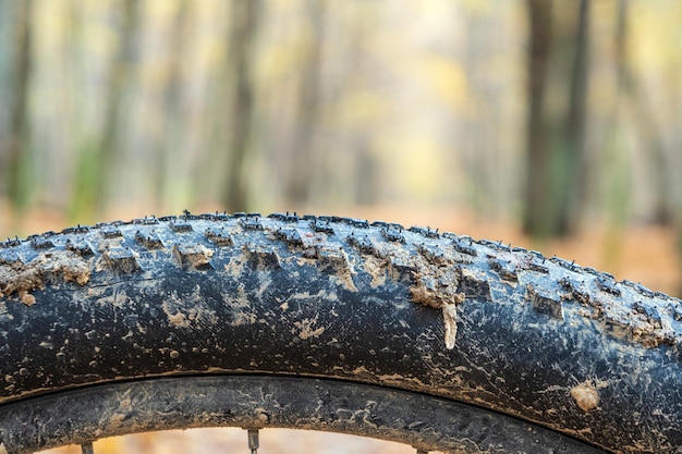 Pneu de bicicleta na lama a lama gruda em uma roda de bicicleta após o ciclismo foco seletivo