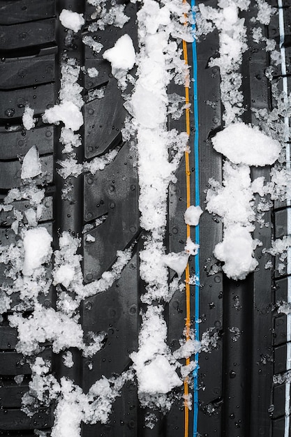 Pneu de carro com neve e gelo na temporada de inverno